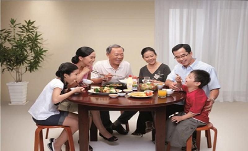 Hình ảnh một gia đình (có mẹ, bố, bé) ngồi cùng nhau thưởng thức bữa ăn (không nhất thiết là mì hồng) trong không khí ấm cúng, có thể là ở nhà hoặc quán ăn sạch sẽ